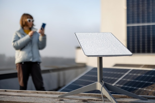 Photo starlink satellite dish on roof of residential building and woman on background