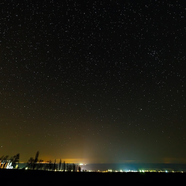 照らされた街の上の星空。