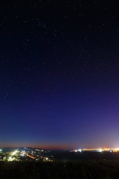 The starry sky above the lighted lanterns city. blur