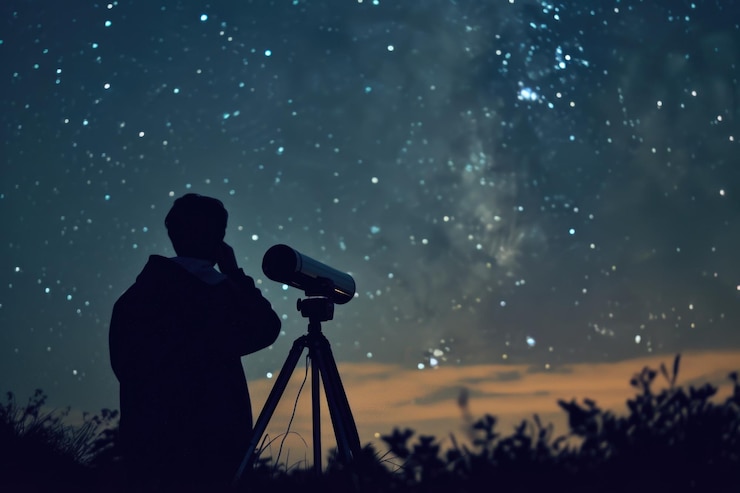 Photo starry sky with a man sitting in a field looking at the stars