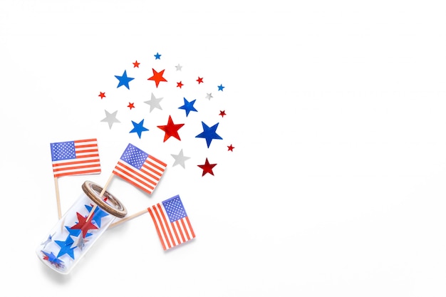 Stars confetti, american flags fly out the glass isolated on white backdrop. Space for text. Fourth of july. Decor for independence day of America.  
Space for text