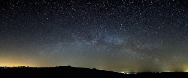 スカイラインの上の夜空にある天の川銀河の星。星空のパノラマビュー。