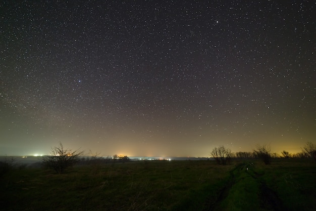 Stars in the night sky over a dirt road