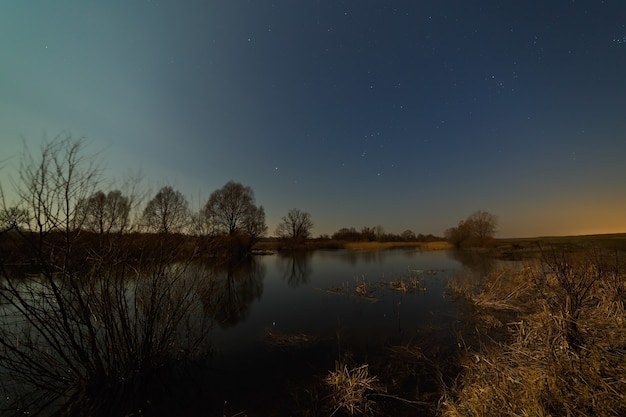 Stars in the night sky over the river. Early spring in central Russia