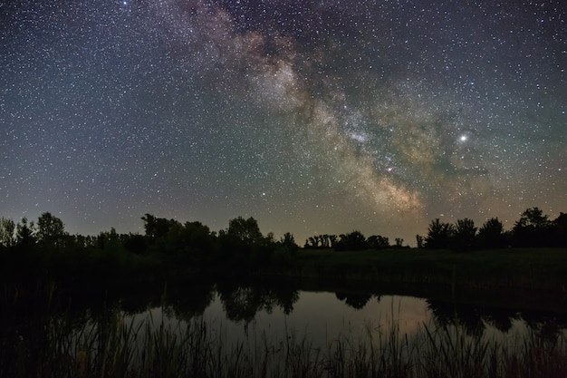 Photo stars in the sky at night. bright milky way over the lake