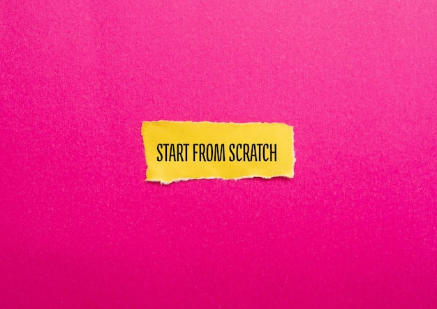 Start from scratch words written on yellow torn paper with pink background