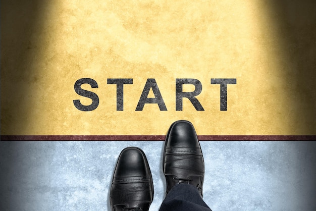 Start line start background top view of businessman with shoes
is standing next to line and word start business challenge or do
something new