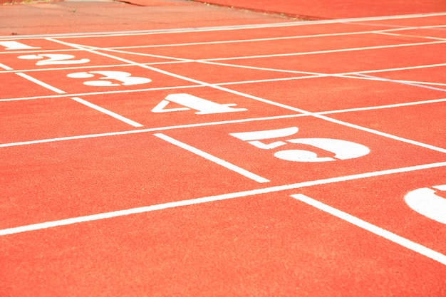 Photo start of red athletic track with numbers. sport concept