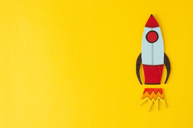 Start up business . Boost or increase incomes, salary. Drawn rocket on colorful yellow . copyspace.