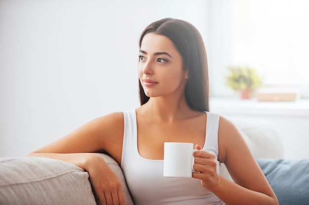 Startdag met kopje verse koffie. Mooie jonge vrouw met koffiekopje