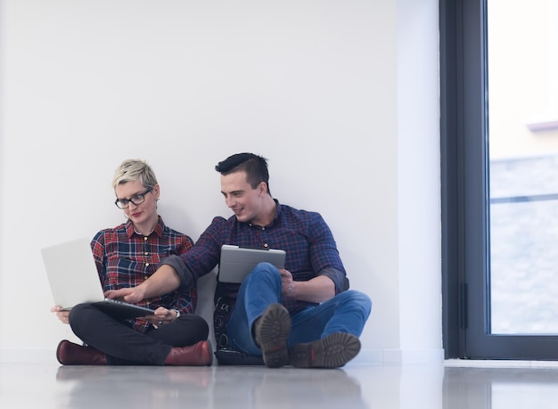 startend bedrijf en nieuw concept voor mobiele technologie met jong stel in modern licht kantoorinterieur dat werkt op laptop en tabletcomputer aan nieuw creatief project en brainstormen