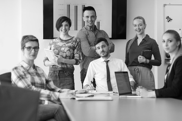 Startend bedrijf jonge creatieve mensen groep brainstormen over vergadering op kantoor met behulp van laptop en tabletcomputer om ideeën plannen en projecten te noteren zonsopgang of zonsondergang met zonnevlam op de achtergrond