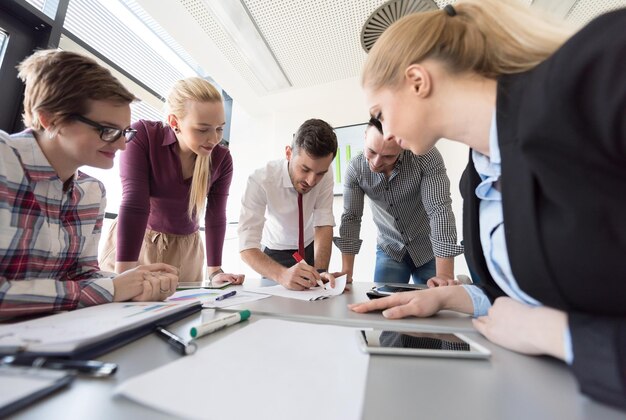 startend bedrijf, jonge creatieve mensengroep brainstormen over ontmoeting op kantoor, laptop en tabletcomputer gebruiken om ideeënplannen en projecten te noteren