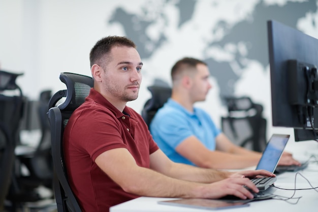 startend bedrijf, twee mannelijke softwareontwikkelaars die aan de computer werken bij een nieuw modern open kantoor