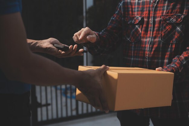 Startende kleine ondernemer van freelance Aziatische vrouw die een laptop met doos gebruikt Vrolijke succes Aziatische vrouw haar hand tilt online marketing verpakkingsdoos en levering MKB-ideeconcept op