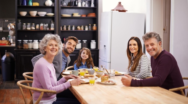 Starting the day with loved ones Portrait of a family eating breakfast around the kitchen table