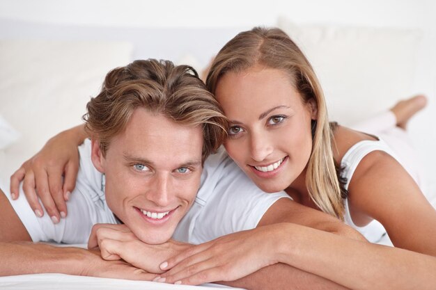 Starting each day with a smile Cropped view of a young couple lying in bed together