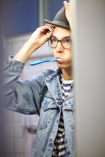 Starting his day Trendy young guy getting ready for the day by brushing his teeth