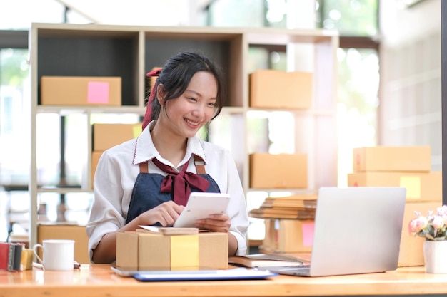 Starting Small business entrepreneur SME freelancePortrait jonge vrouw die thuis werkt kantoor BOXsmartphone laptop online marketing verpakking levering SME e-commerce concept