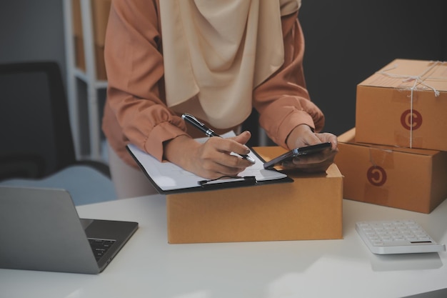 Starting small businesses SME owners female entrepreneurs Write the address on receipt box and check online orders to prepare to pack the boxes sell to customers sme business ideas online