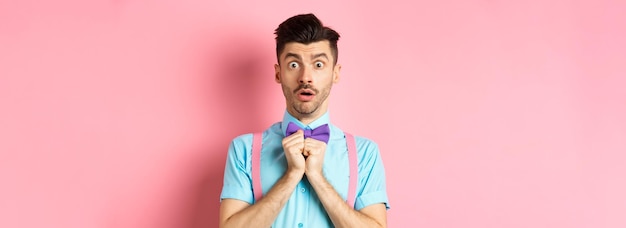 Startled and worried classy man in moustache gasping and holding breath shocked standing oin bowtie