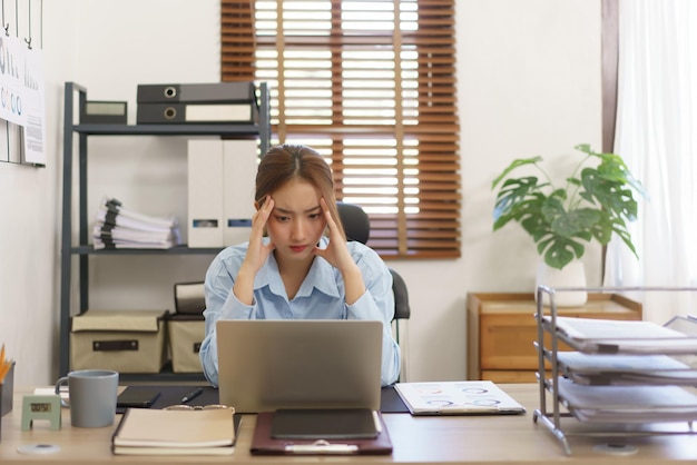 Startup business concept Businesswomen stressful while reading finance data on laptop at workplace