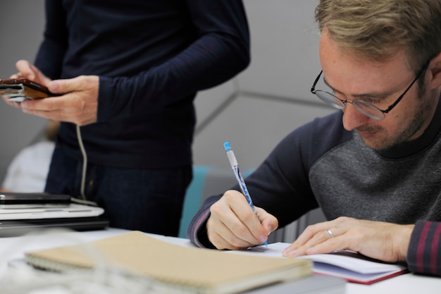 Startup Business People Writing on Notebook