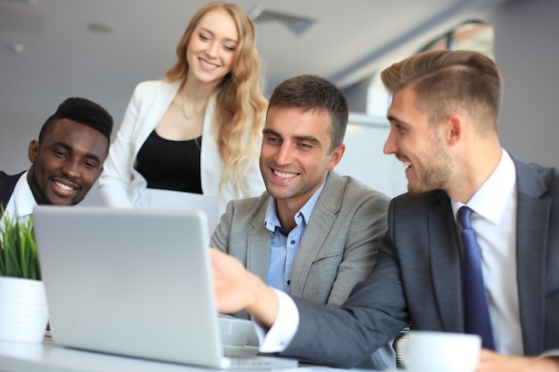 Startup business team bij het ontmoeten in een modern, helder kantoorinterieur brainstormen, werken op laptop en tabletcomputer