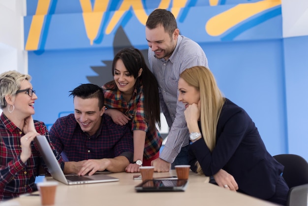 Startup business team bij het ontmoeten in een modern, helder kantoorinterieur brainstormen, werken op laptop en tabletcomputer