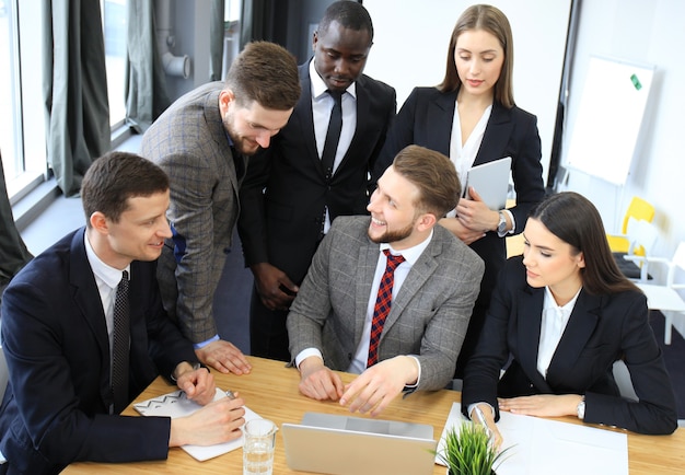 Startup business team on meeting in modern bright office interior and working on laptop.