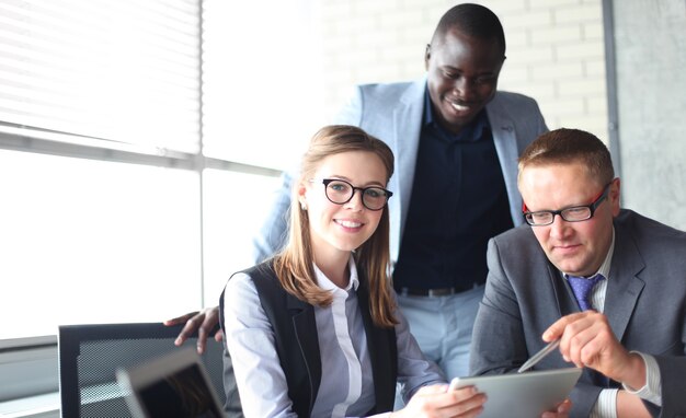 Foto startup business team op ontmoeting in moderne, lichte kantoorinterieur brainstormen, werken op laptop en tabletcomputer