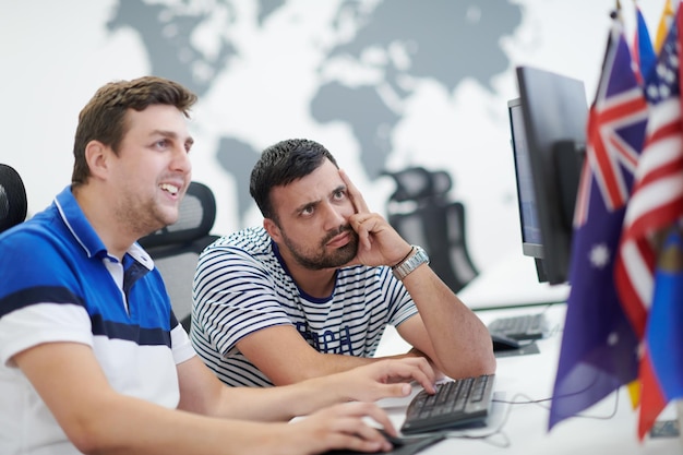 Startup business, two male software developers working on\
computer at new modern open plan office