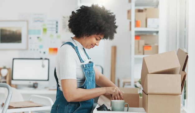 Photo startup delivery and shipping in boxes for online shopping business businesswoman packing products from online business in a box to ship to clients and buyers black woman working in the office