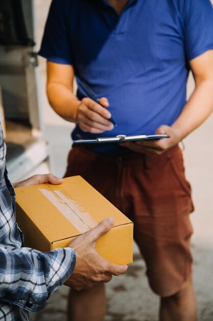 Photo startup small business entrepreneur of freelance asian woman using a laptop with box cheerful success asian woman her hand lifts up online marketing packaging box and delivery sme idea concept