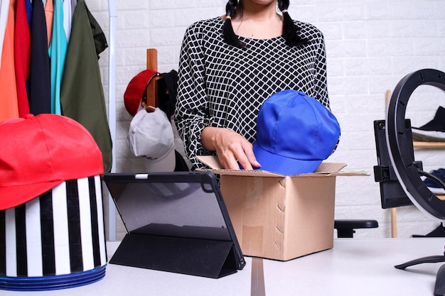 Startup small business entrepreneur sme asian woman packing a cap in box