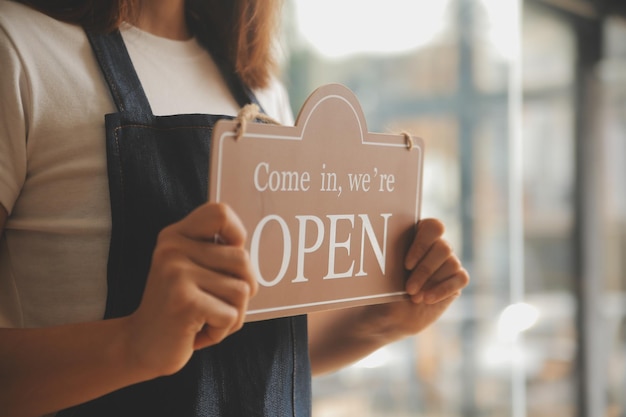 Foto startup di successo proprietario di piccola impresa sme bellezza ragazza stand con tablet smartphone in caffetteria ristorante ritratto di asiatica donna abbronzata barista proprietario di caffetteria imprenditore pmi venditore concetto di business