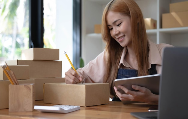 Startup successful small business owner sme beauty girl stand with tablet smartphone in coffee shop restaurant Portrait of asian tan woman barista cafe owner SME entrepreneur seller business concept