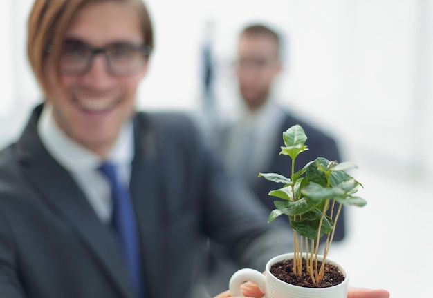 Startupyoung businessman shows young sprout