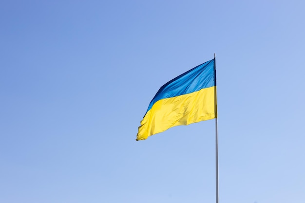 Государственный флаг Украины на фоне голубого неба