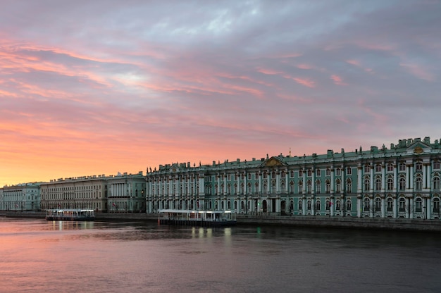 Государственный Эрмитаж на Дворцовой набережной на фоне розового рассветного неба Санкт-Петербург Россия