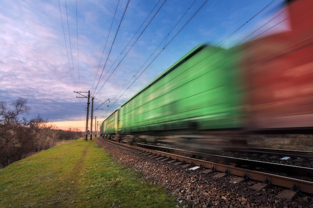 Foto station met goederenwagons in beweging bij zonsondergang