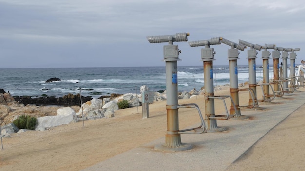 Stationary binoculars telescope tower viewer spyglass or scope ocean beach