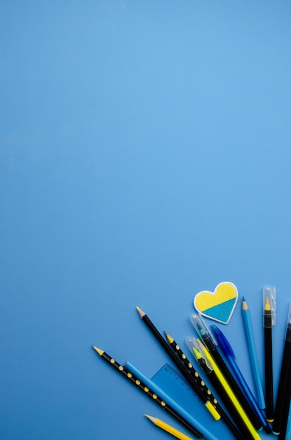 Stationery and heart with colors of the Ukrainian flag on a blue background