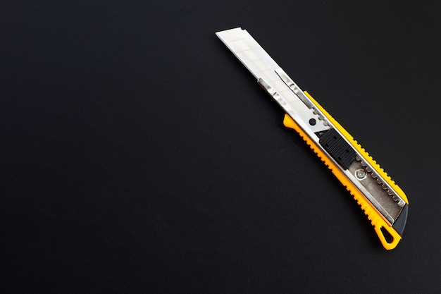 Stationery knife on dark background.