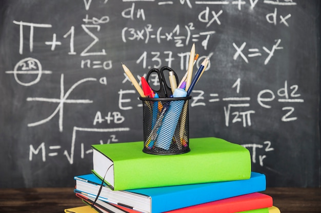 Photo stationery on pile of books near chalkboard