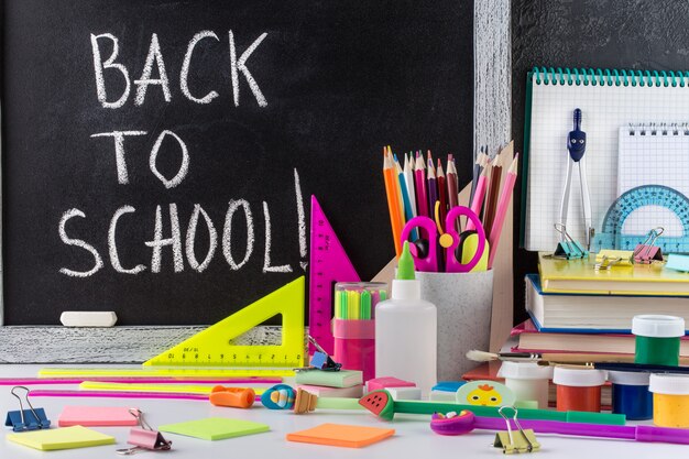 stationery on a table in front of blackboard