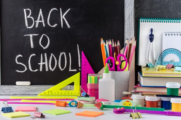 Stationery on a table in front of blackboard