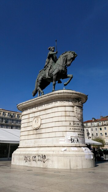 Statue against blue sky in city