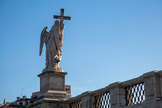 A statue of an angel with a cross on top of it