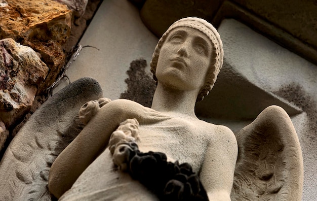 A statue of an angel with wings and a ring on her finger.